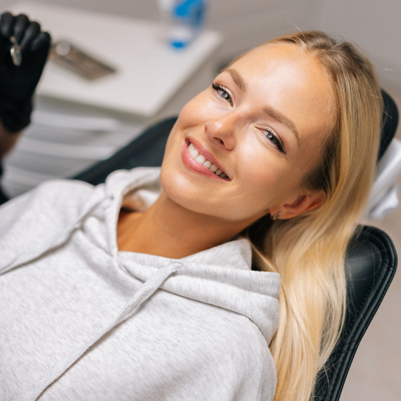 Patient holding up a dental shade guide guide to her teeth